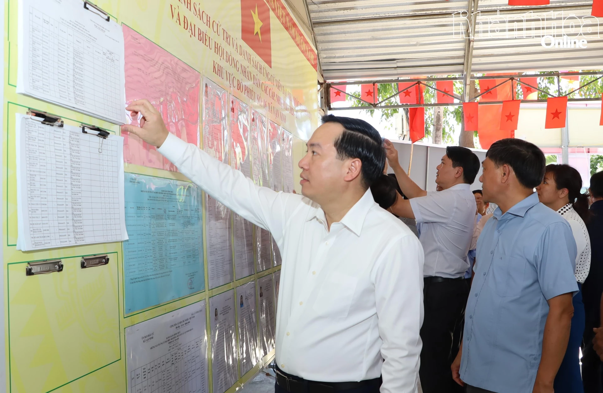 Đồng chí Hồ Xuân Trường kiểm tra danh sách niêm yết cử tri tại thôn 9 xã Vạn Ninh.