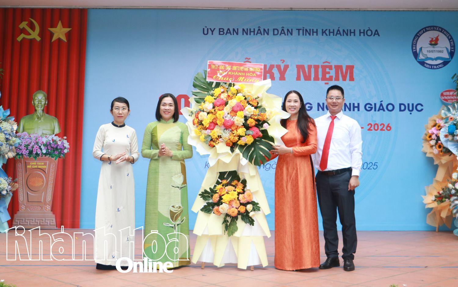 Đồng chí Trần Thu Mai tặng lẵng hoa chúc mừng Trường THPT Nguyễn Thiện Thuật.