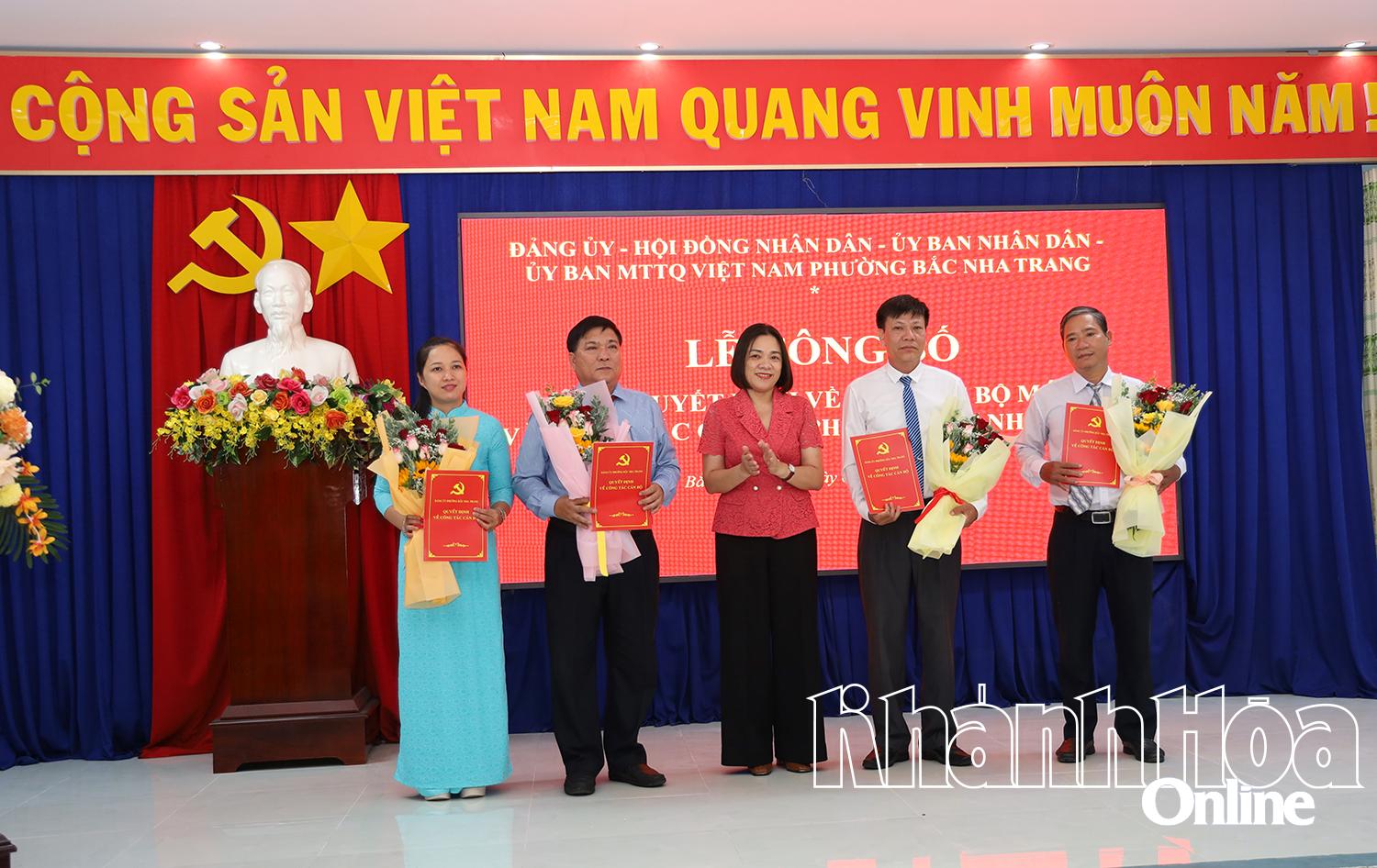 Đồng chí Trần Thu Mai trao quyết định và tặng hoa chúc mừng các đồng chí trong Ban Thường trực UBMTTQ Việt Nam phường.