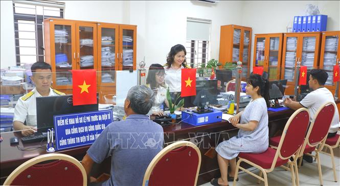 Hỗ trợ giải quyết thủ tục hành chính tại bộ phận 1 cửa cơ quan Thuế đầu tháng 7/2025. Ảnh: TTXVN phát