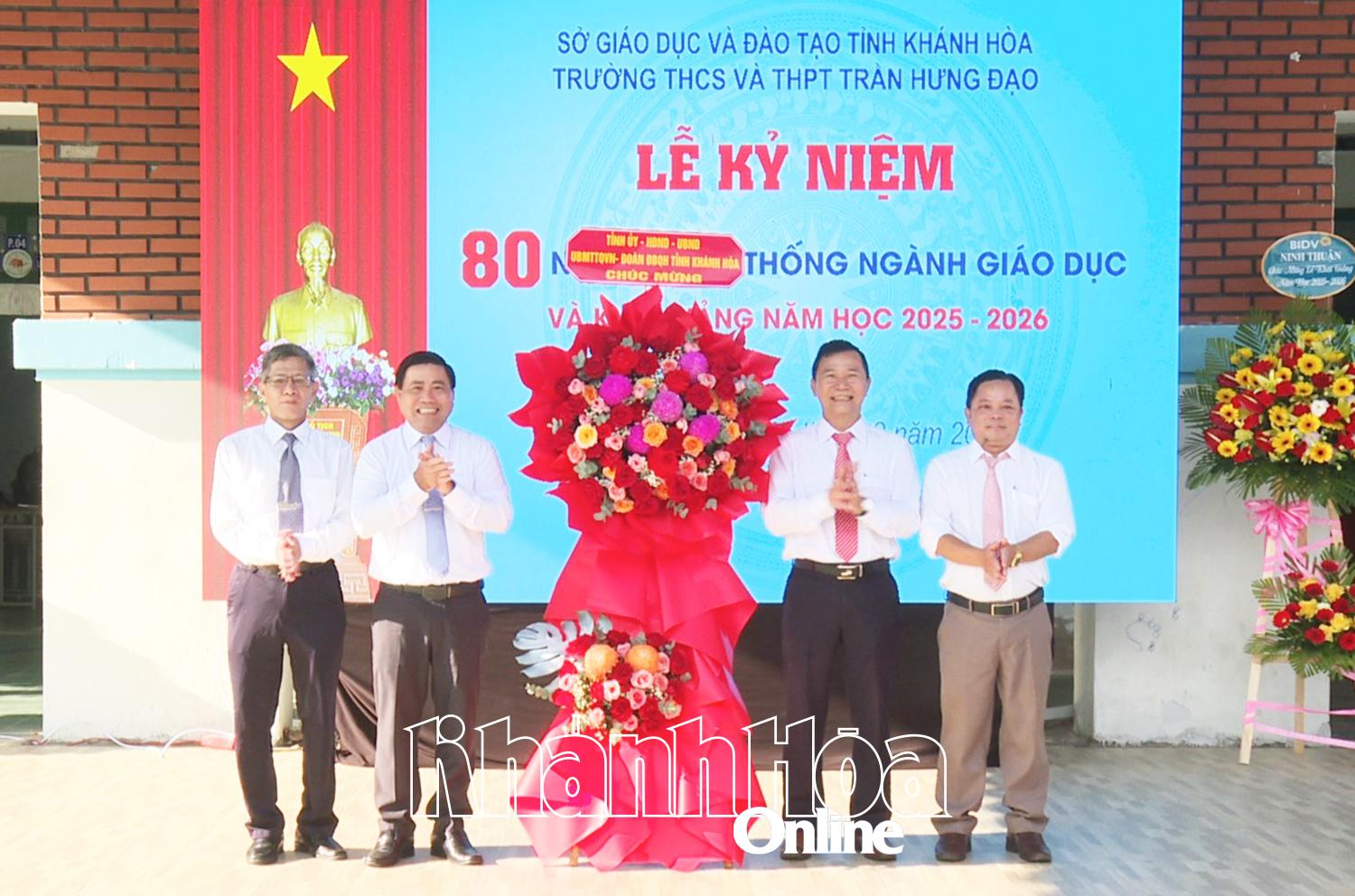Đồng chí Lâm Đông tặng hoa chúc mừng năm học mới cho đại diện Ban Giám hiệu nhà trường.