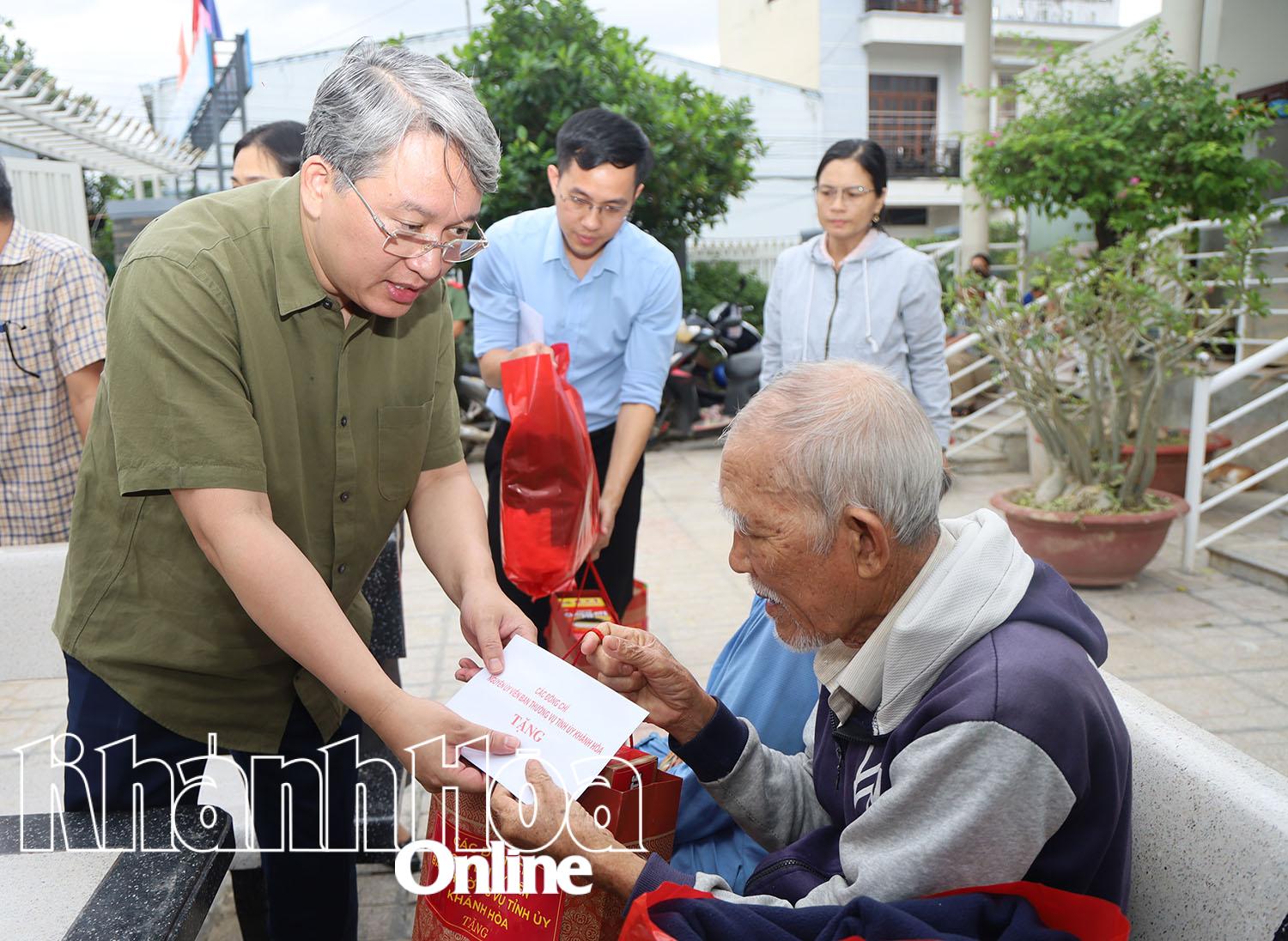Đồng chí Nguyễn Hải Ninh trao quà hỗ trợ các hộ dân.  