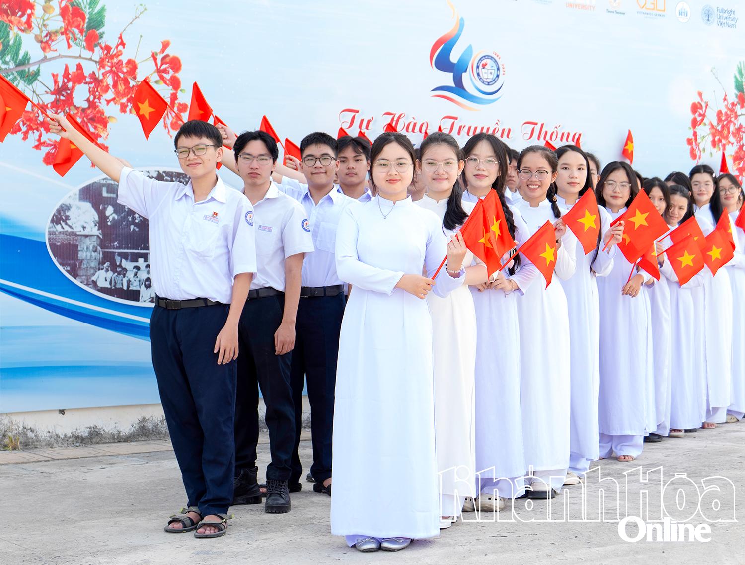 Các học sinh Trường THPT Chuyên Lê Quý Đôn (phường Nam Nha Trang) chụp hình với lá cờ Tổ quốc trên tay. Ảnh: VƯƠNG MẠNH CƯỜNG