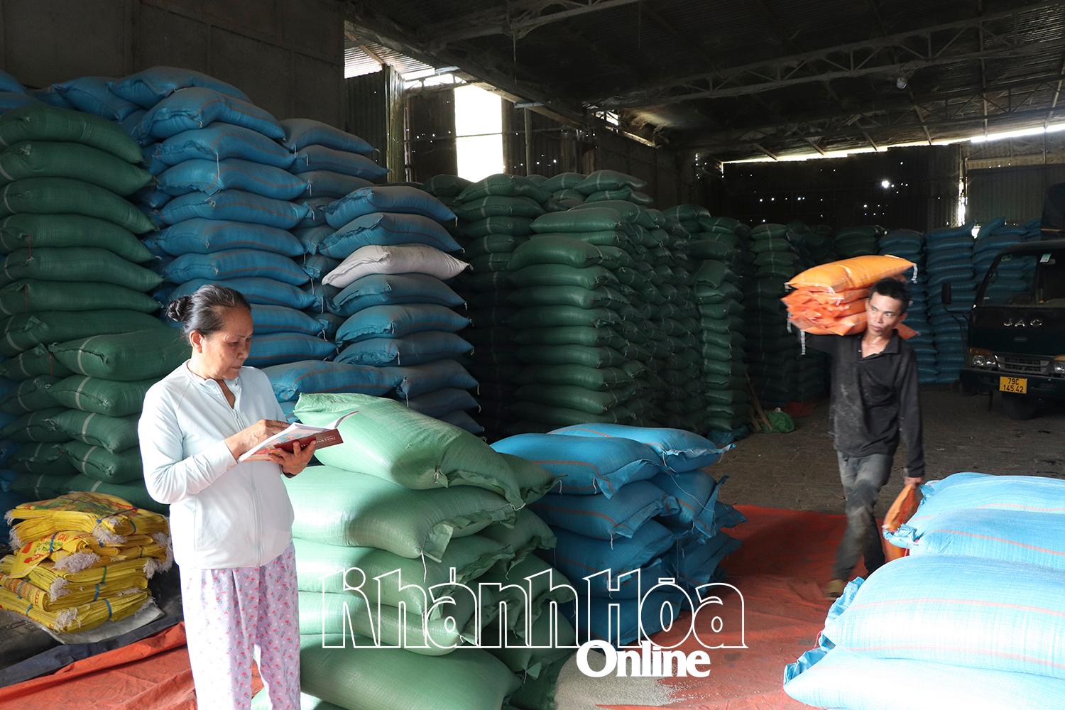 Bà Lưu Thị Minh Hiền kiểm đếm gạo để nhân viên bốc lên xe và giao cho khách hàng.  