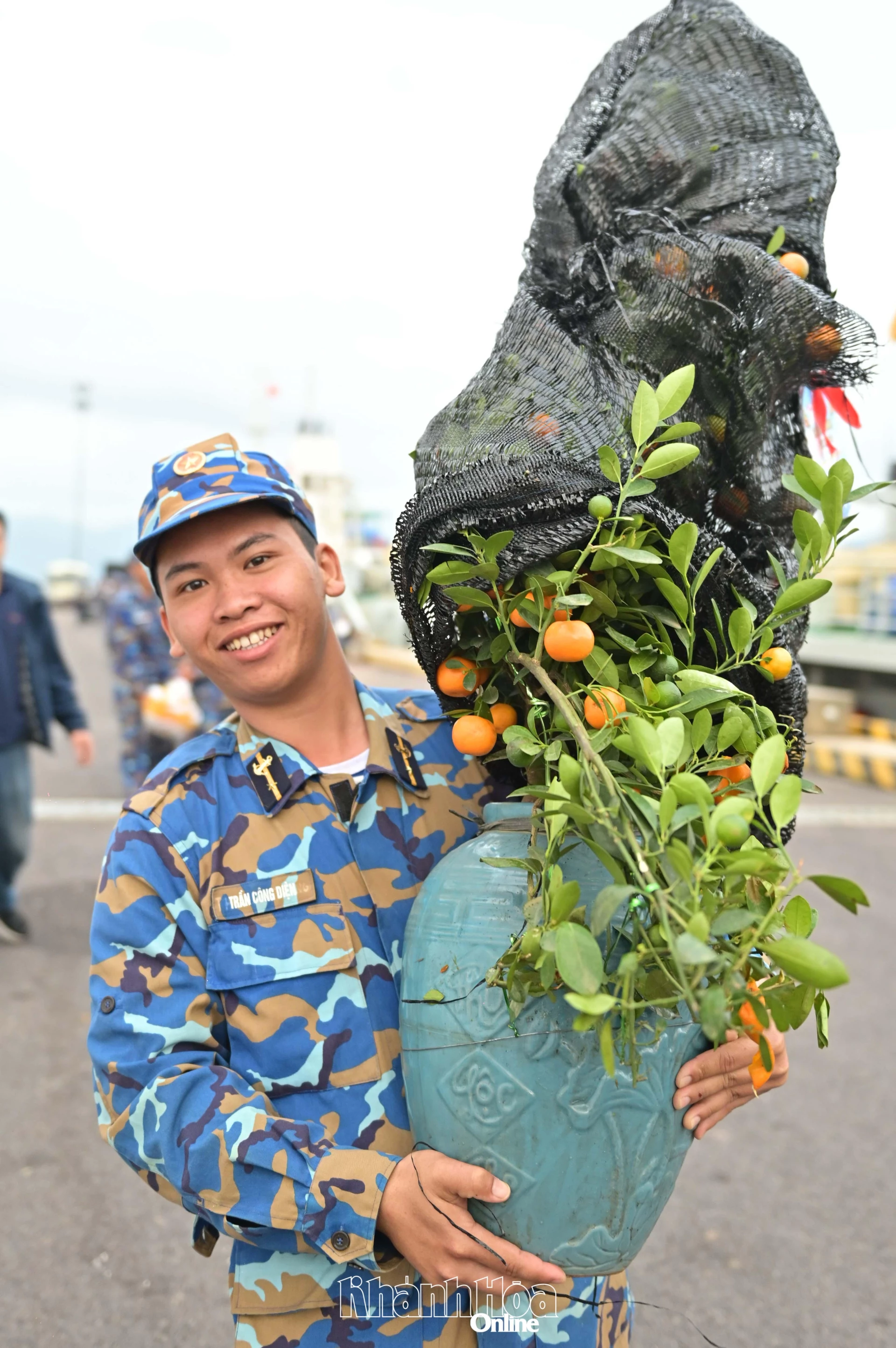 Chiến sĩ trẻ với chậu quất trên tay, được mang ra đảo để phục vụ đón Tết.