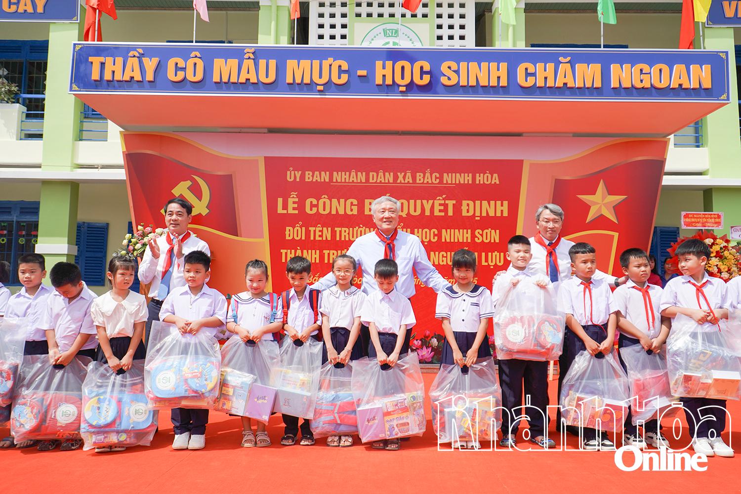 Đồng chí Nguyễn Hòa Bình và các đại biểu tặng quà cho các học sinh.
