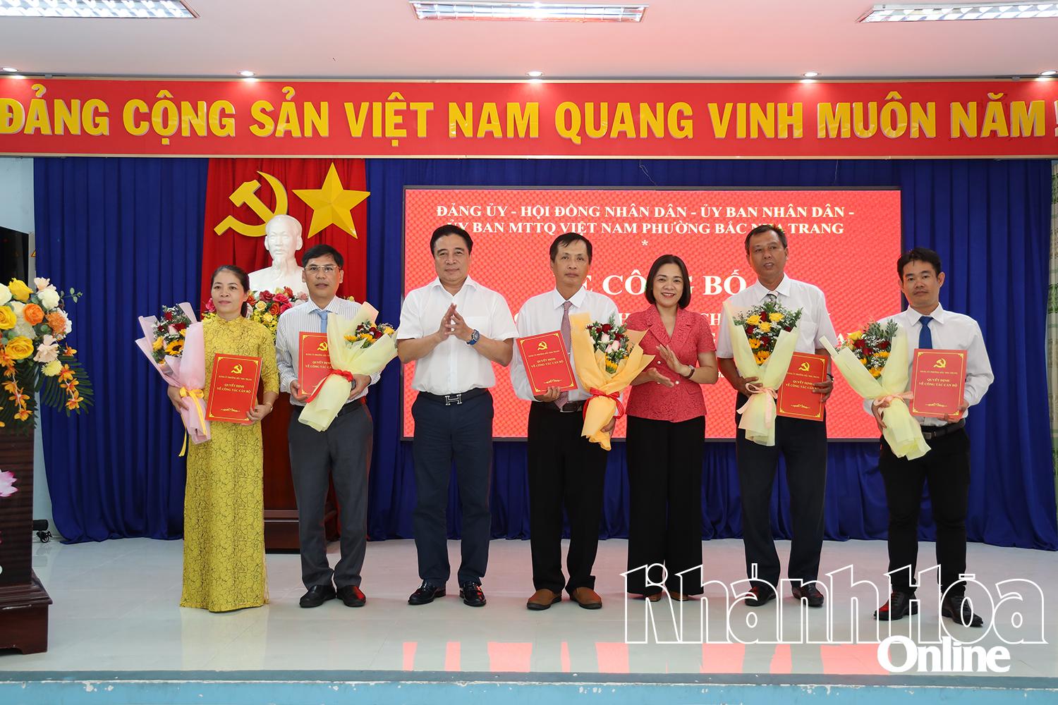 Đồng chí Nguyễn Khắc Toàn và đồng chí Trần Thu Mai trao quyết định và tặng hoa chúc mừng Ủy ban Kiểm tra Đảng ủy phường.