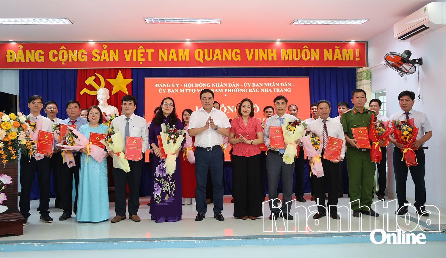 Đồng chí Nguyễn Khắc Toàn và đồng chí Trần Thu Mai trao quyết định và tặng hoa chúc mừng Ban Chấp hành Đảng bộ phường.