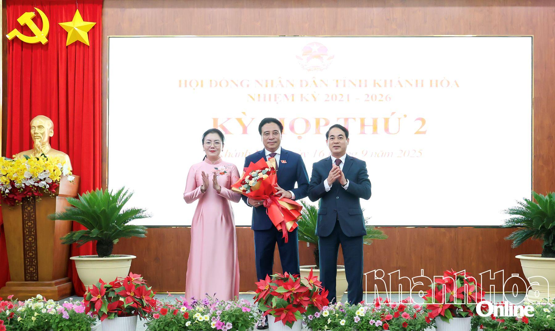 Bí thư Tỉnh ủy Nghiêm Xuân Thành và đồng chí Phó Chủ tịch HĐND tỉnh Phạm Thị Xuân Trang tặng hoa chúc mừng Chủ tịch UBND tỉnh Nguyễn Khắc Toàn.