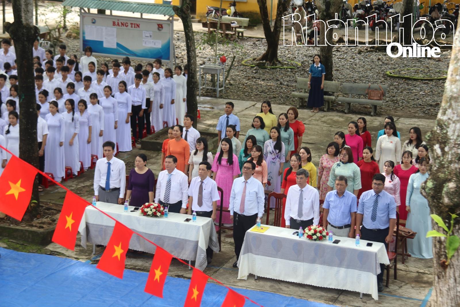 Các đại biểu cùng các em học sinh thực hiện nghi thức chào cờ