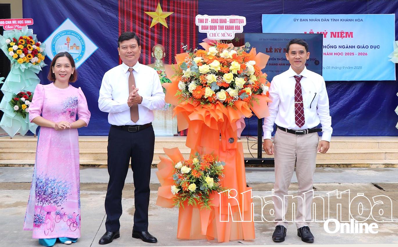 Đồng chí Nguyễn Quang Nhật (thứ 2 từ trái sang) tặng hoa chúc mừng thầy và trò Trường THPT Võ Nguyên Giáp.