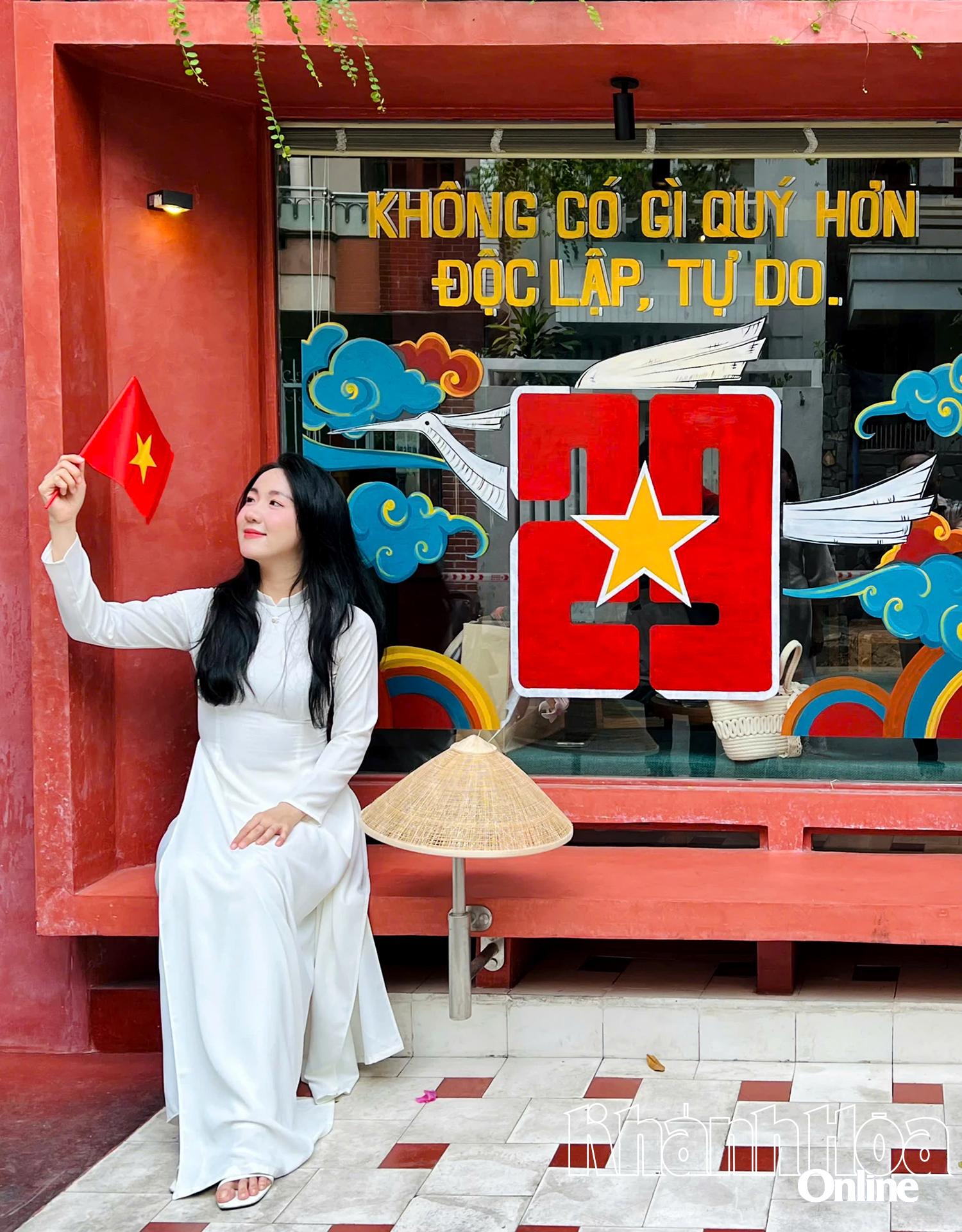 Các bạn trẻ thích thú check-in với cờ đỏ sao vàng tại một quán cà phê trên đường Lê Quý Đôn (phường Nha Trang). Ảnh: XUÂN THÀNH.